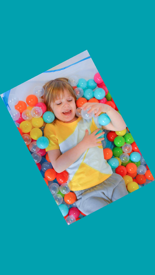 Sensory friendly outfit on autistic model in a ball pit.