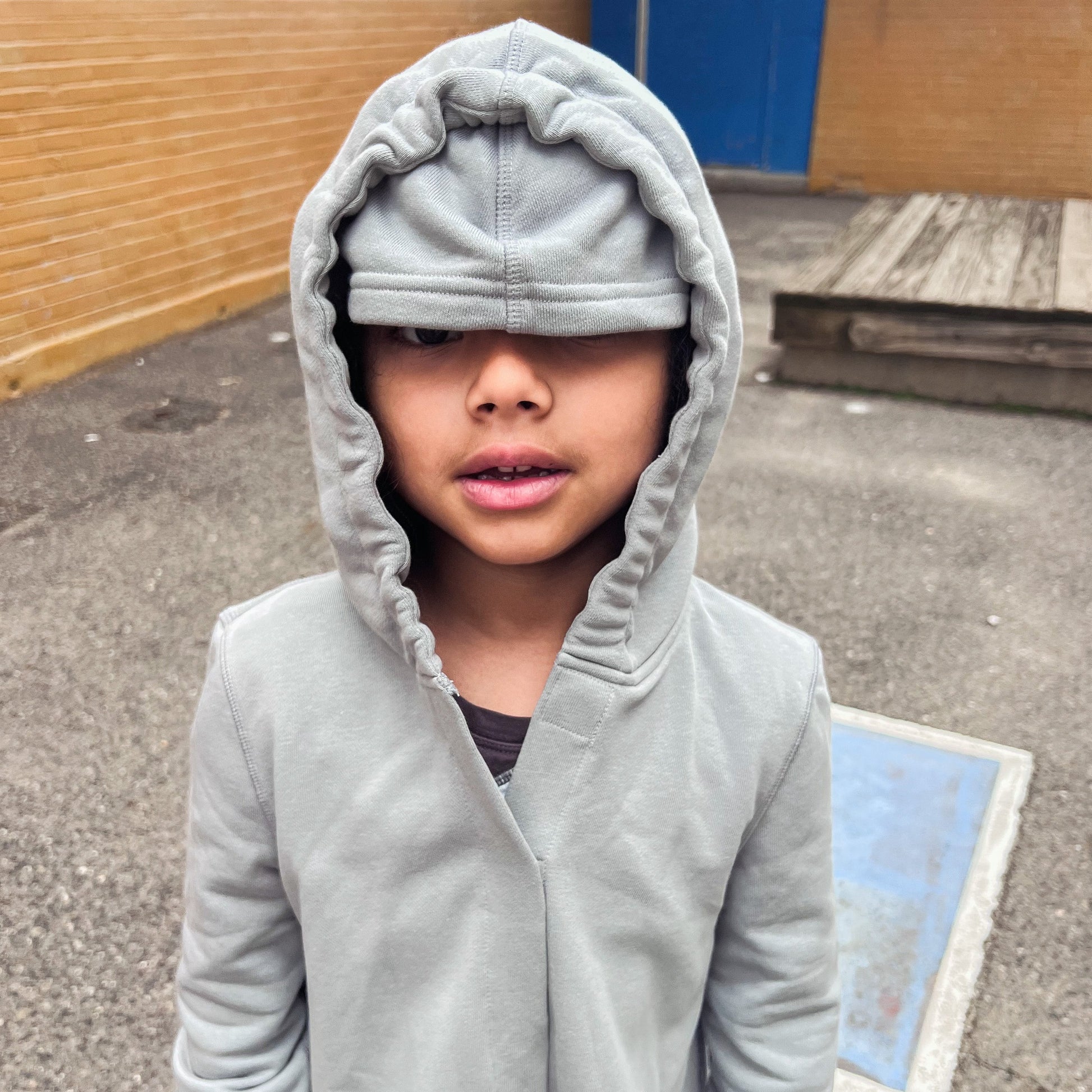 Sensory break hoodie. Autistic boy wearing sound reducing hood and eye mask down for a sensory break.