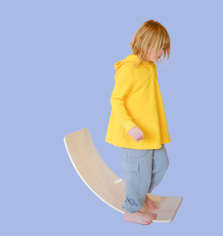 Autistic model on balance board in sensory friendly clothing bundle.